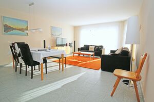 Helles Wohn-/Esszimmer mit grosser Fensterfront und Zugang zum Balkon