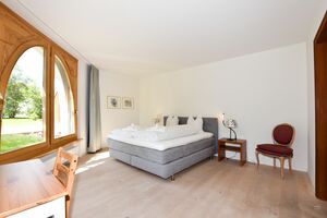 Schlafzimmer mit Doppelbett und Zugang zum Gartensitzplatz