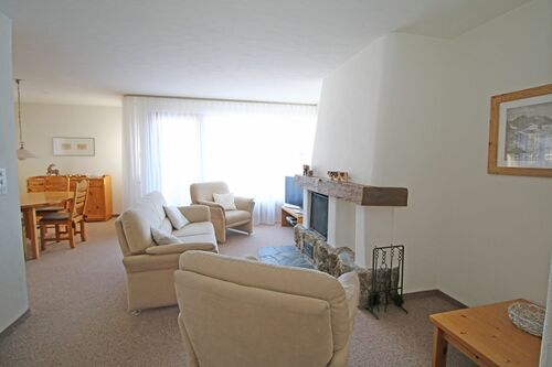 Helles Wohnzimmer mit Cheminée und Zugang zum Balkon
