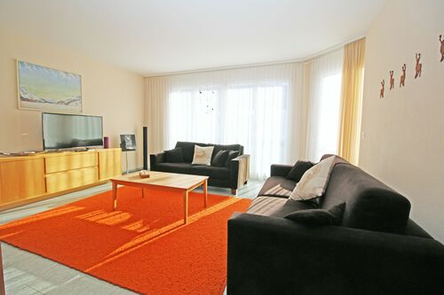 Helles Wohn-/Esszimmer mit grosser Fensterfront und Zugang zum Balkon