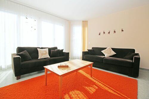 Helles Wohn-/Esszimmer mit grosser Fensterfront und Zugang zum Balkon